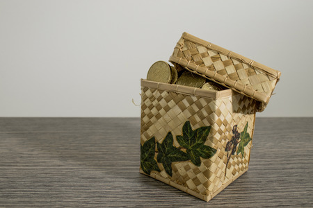 Box full of shiny euro coins on a decorated wood table composition