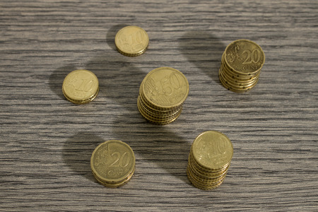 Stacks of euro coins on a decorated wood table composition