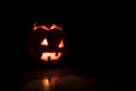Scary orange halloween pumpkin in the darkness compositionの写真素材