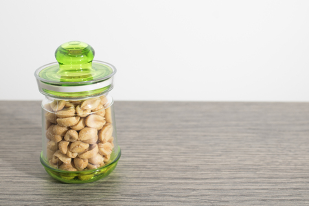 Peanuts in a jar on a wood table compositionの写真素材