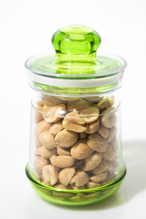 Peanuts in a jar isolated in a white background compositionの写真素材