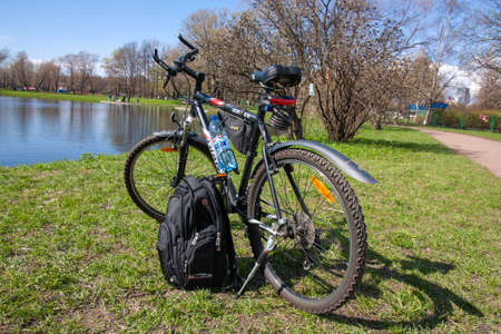 Russia, Saint-Petersburg - 04 May 2015: bike stands in front of the lake and green grassのeditorial素材