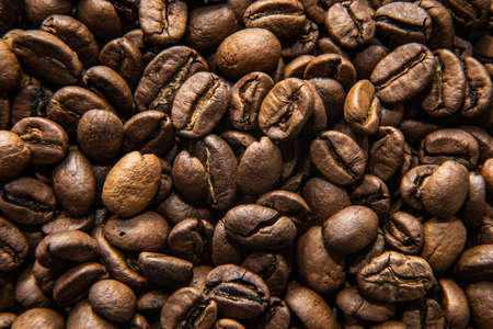 many coffee beans lie together on the tableの写真素材