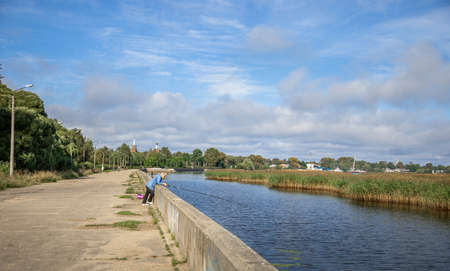 Russia, Tver region - 07 September 2020: landscape from the embankment of Lake Seliger. Man fishing...