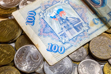 Russian old banknote of 100 rubles lies among the coinsの写真素材