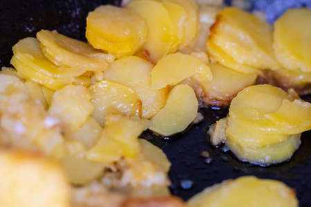Fried golden potatoes in a pan close-upの写真素材
