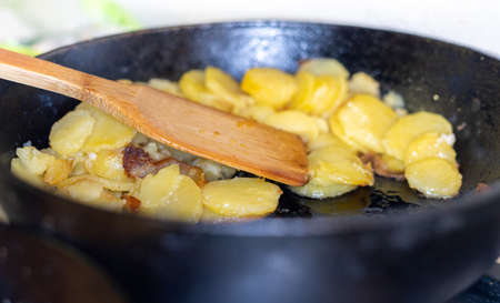 fried golden potatoes in a pan close-upの写真素材