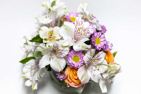 bouquet of flowers in a round small vase on a white backgroundの写真素材