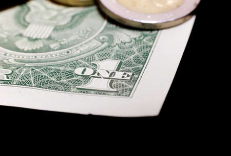 American paper dollar and European coin lie together. Close up. Metal coins on paper banknotesの写真素材