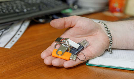 different USB flash drives are in the man's hand