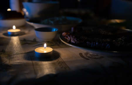 candle is lit on a holiday table in a dark room