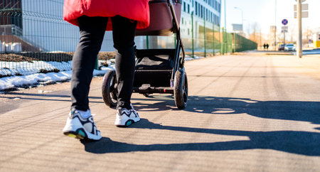 mom walks on the street with a baby in a stroller, stroller close-up, bottom view