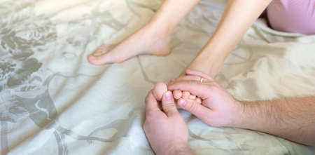 a man doing a foot massage to his wife