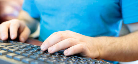 man is typing something on the keyboard, close-up of handsの写真素材