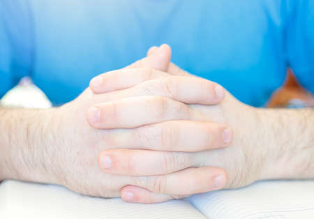man folded his fingers on the background of the diary