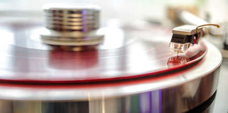 tonearm cartridge close up against red vinyl backgroundの写真素材