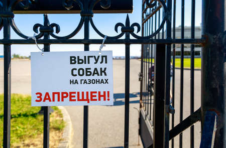 blank white label "walking dogs on lawns is prohibited" on black metal grateの写真素材