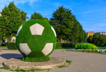 big green soccer ball set on city streetの写真素材