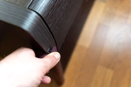 man covers baby safety corner protector of the dresser for the safety of the babyの写真素材