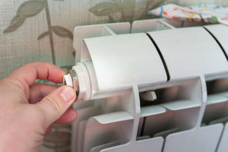 man repairing a water battery in a house