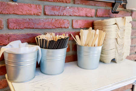 wooden ice cream sticks and cocktail tubes are in small iron bucketsの写真素材