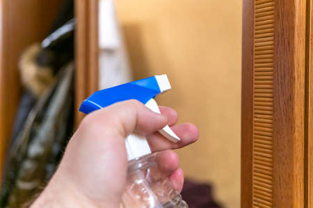 man sprays mirror cleaner, hand close-upの写真素材