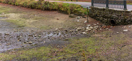 stone bridge with a metal pipe, dry streamの写真素材