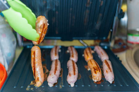 pork and beef sausages made on an electric grillの写真素材