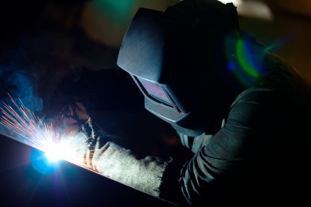 Photo of a welding process wtih sparks flying around (with copy space)