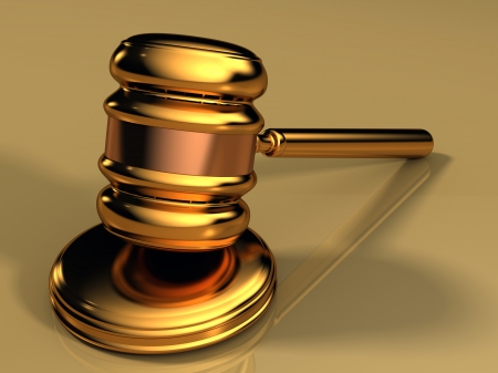 Golden gavel isolated against a gold background with reflectionsの写真素材