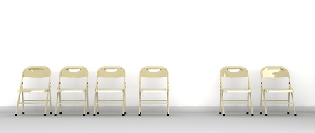 A row of metal chairs against a wall with one missingの写真素材