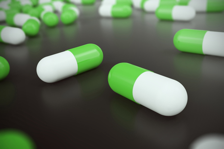 Heap of green white round capsule pills with medicine antibiotic in packages on black background. 3d illustration.の写真素材