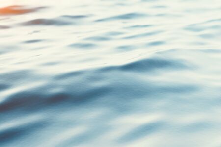 Blue water background with ripples, sea, ocean wave low angle view. Close-up Nature background. Soft...