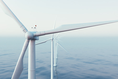 Wind farm turbines caught in sunset sky. Beautiful contrast with the blue sea. ecological concept....
