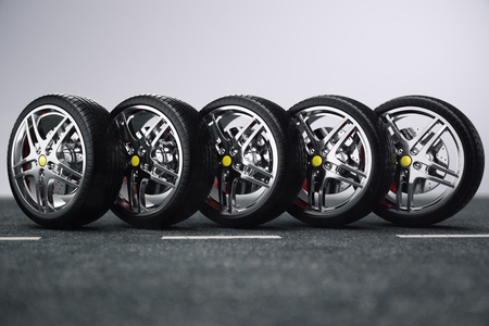Car wheel, car tire standing on a road. Concept tyres. Car tire with a disc standing on the asphalt...