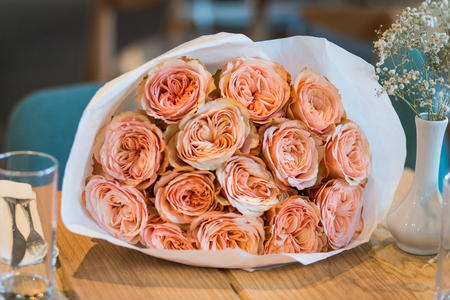Bouquet of roses David Austin in craft paper on wooden tableの写真素材