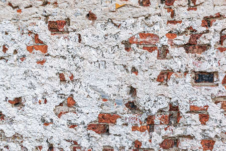 Old chipped white brick wall texture background, whitewashed grungy brick wall, abstract red white vintage background. in a detailed view of the surface structure. Detailed view in excellent quality.の写真素材