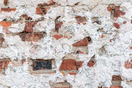 Old chipped white brick wall texture background, whitewashed grungy brick wall, abstract red white vintage background. in a detailed view of the surface structure. Detailed view in excellent quality.の写真素材