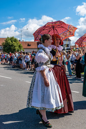 Straznice, Czech Republic - June 25, 2022 International Folklore Festival. Women in folk costumes with parasols with folk motifsのeditorial素材