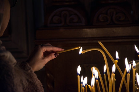 Woman lighting a candle in church