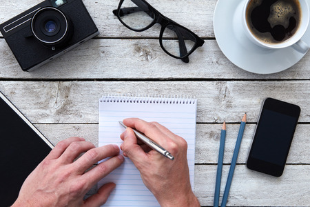 Top view of a hands with pen and coffee on workplaceの写真素材