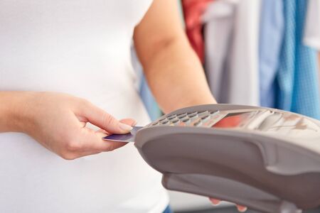Female hand controls payment terminal in shop