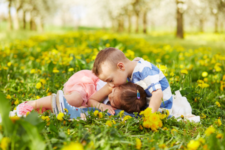 Boy kissing a girl in a blossoming orchardの写真素材