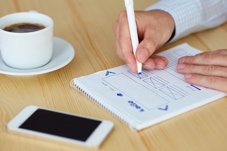 Man sketching web design in office, close up
