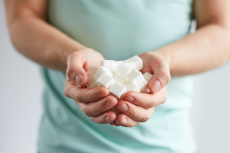 Man with cubes of white sugar in his handsの写真素材