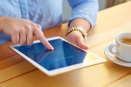 Close up of female hands touching on a tablet online banking