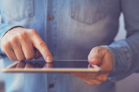 Man touching digital tablet, view close up. Tonedの写真素材