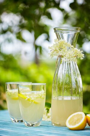 Two glasses and a carafe of elderflower lemonade on tableの写真素材