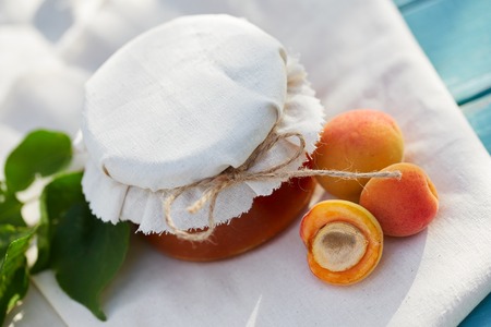 Apricot jam in glass jar with fresh fruit on a wooden tableの写真素材