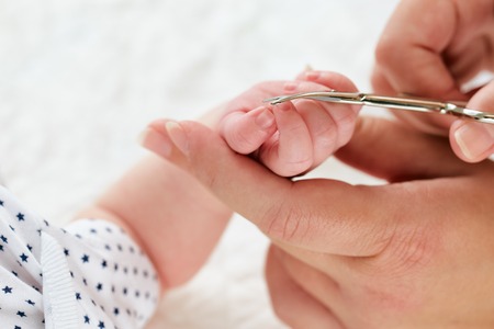 Close up of mother cutting baby's nailsの写真素材